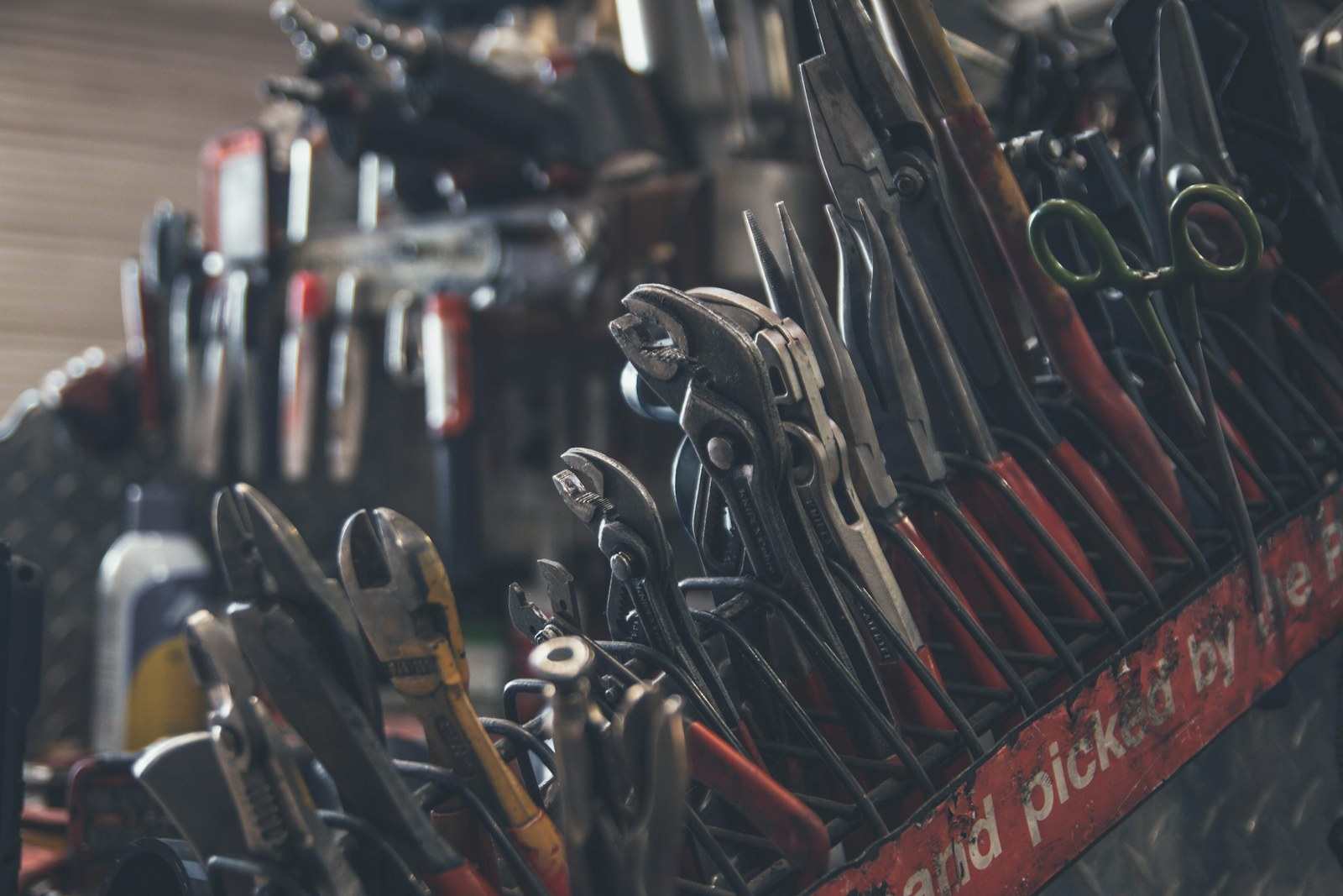 Assorted hand tools organized in a workshop tool rack